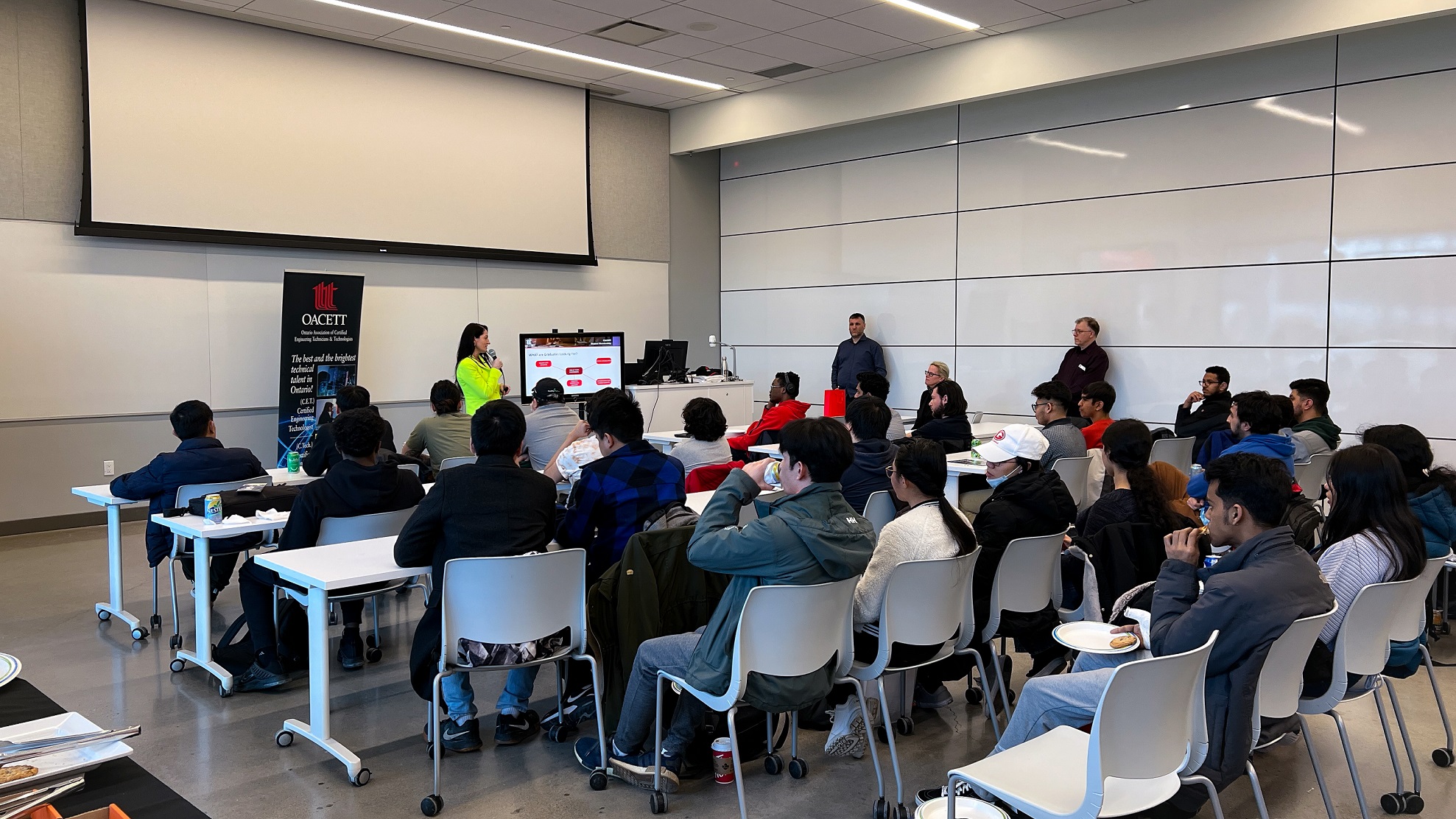 2 Group of people seated at desks looking a presentation