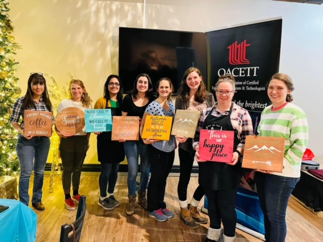 WIT Sign and Sip Group of women holding decorated papers